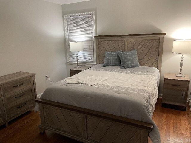 bedroom with dark hardwood / wood-style floors