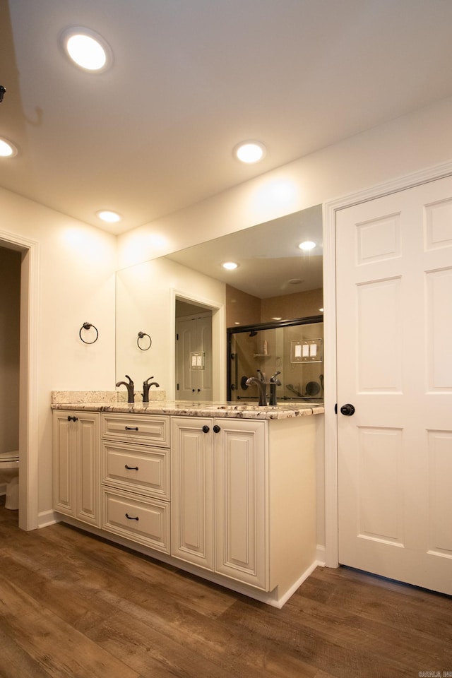 bar featuring dark wood-type flooring, white cabinets, and light stone countertops