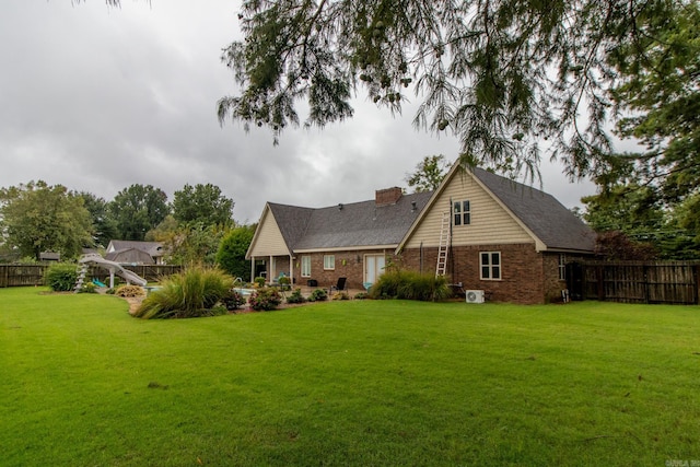 rear view of house featuring a yard