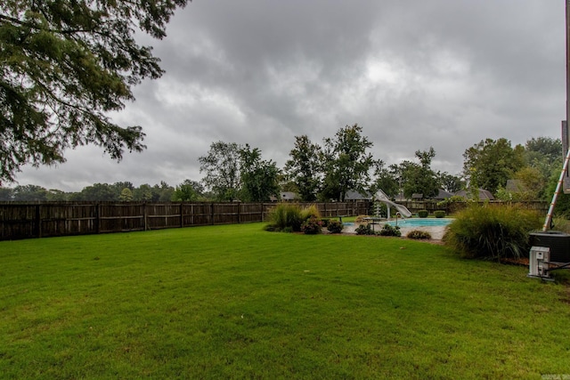 view of yard with a fenced in pool and cooling unit