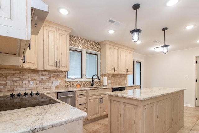 kitchen featuring decorative light fixtures, light stone countertops, sink, black appliances, and a kitchen island