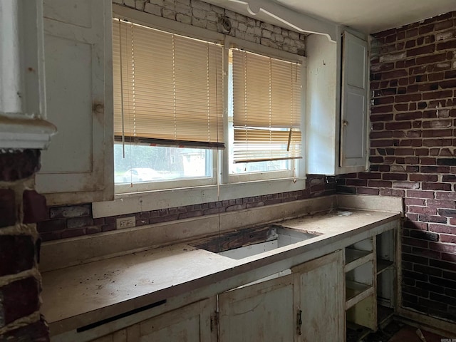 kitchen featuring brick wall