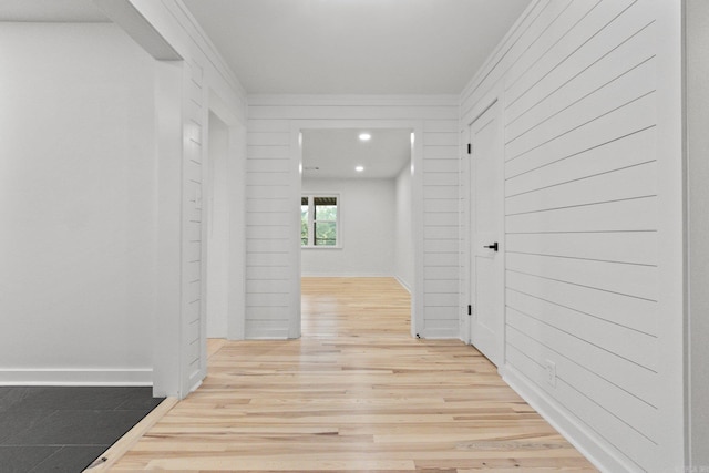 hall featuring ornamental molding and light hardwood / wood-style flooring