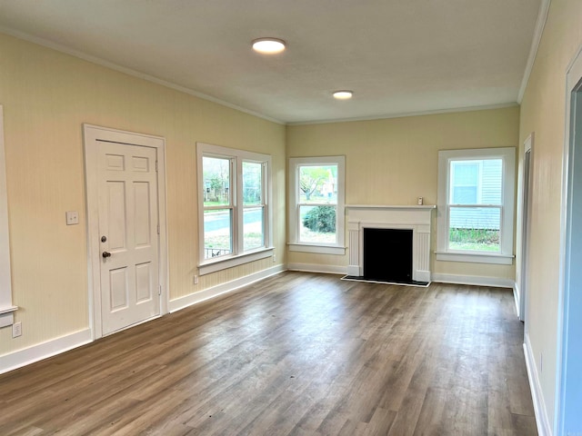 unfurnished living room featuring a healthy amount of sunlight, ornamental molding, and dark hardwood / wood-style flooring