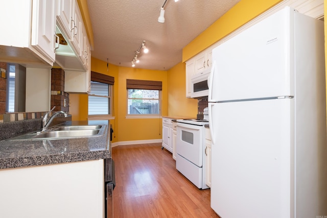 kitchen with white cabinetry, a textured ceiling, white appliances, sink, and light hardwood / wood-style floors