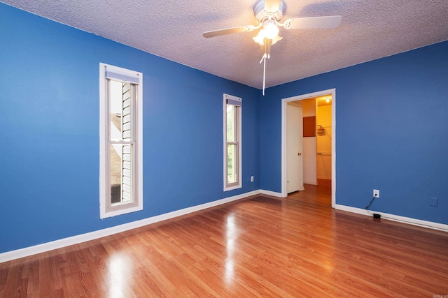 spare room with a textured ceiling, ceiling fan, and hardwood / wood-style flooring