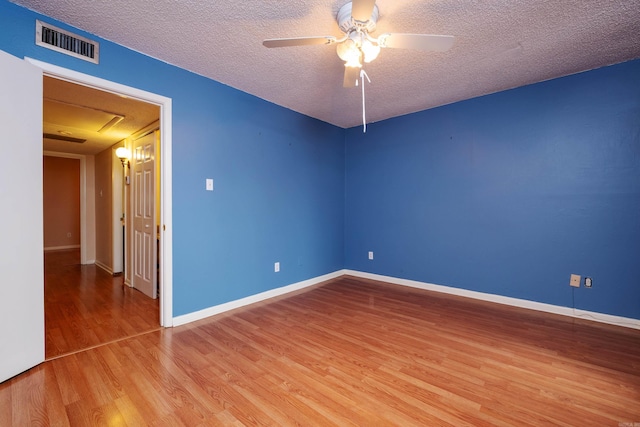 unfurnished room with a textured ceiling, hardwood / wood-style flooring, and ceiling fan