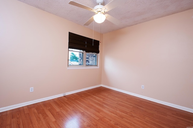 empty room featuring ceiling fan, hardwood / wood-style flooring, and a textured ceiling