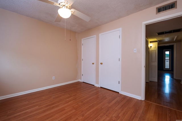 unfurnished bedroom featuring a textured ceiling, ceiling fan, and wood-type flooring