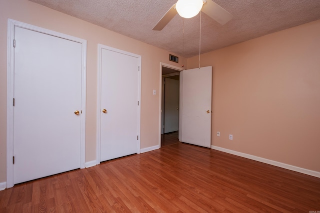 unfurnished bedroom featuring a textured ceiling, ceiling fan, and wood-type flooring