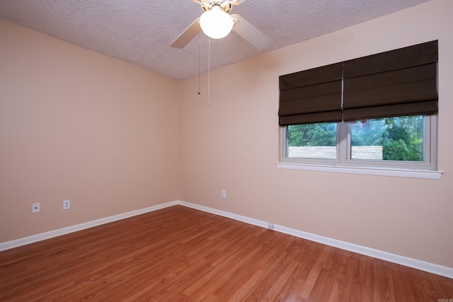 empty room featuring ceiling fan, hardwood / wood-style flooring, and a textured ceiling