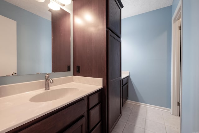 bathroom featuring tile patterned floors, vanity, and a textured ceiling