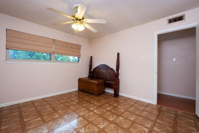 living area with a textured ceiling and ceiling fan