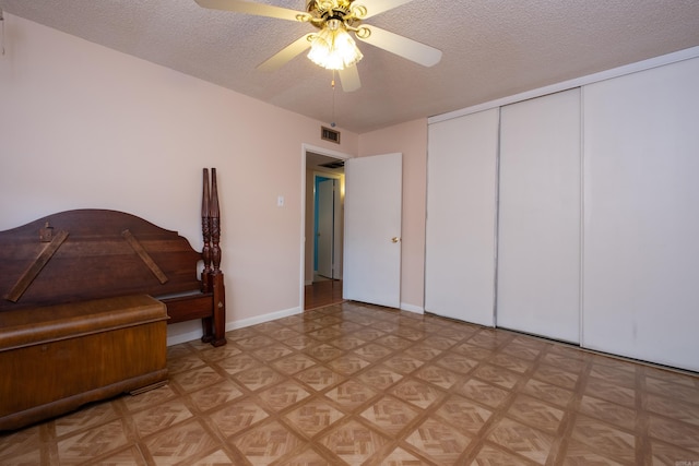 bedroom featuring a closet, ceiling fan, light parquet floors, and a textured ceiling