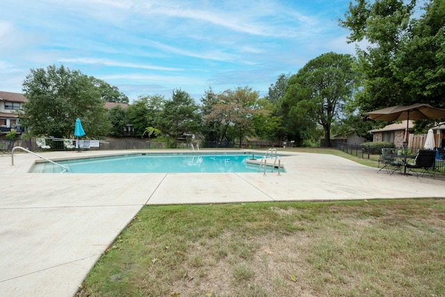 view of pool with a patio area and a lawn