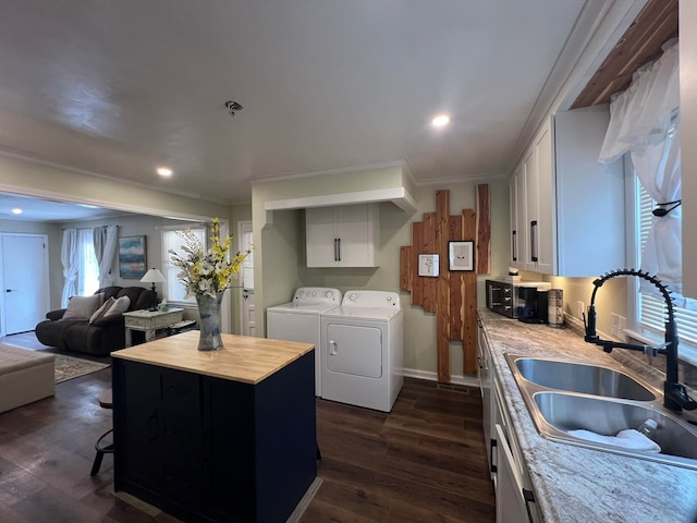 kitchen featuring washer and dryer, dark hardwood / wood-style flooring, plenty of natural light, a center island, and sink