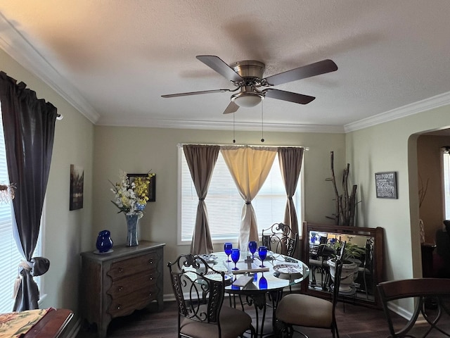 dining room with a textured ceiling, crown molding, ceiling fan, and dark hardwood / wood-style floors