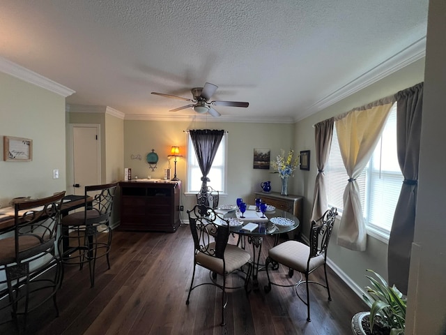 dining room with a textured ceiling, dark wood-type flooring, ceiling fan, and ornamental molding