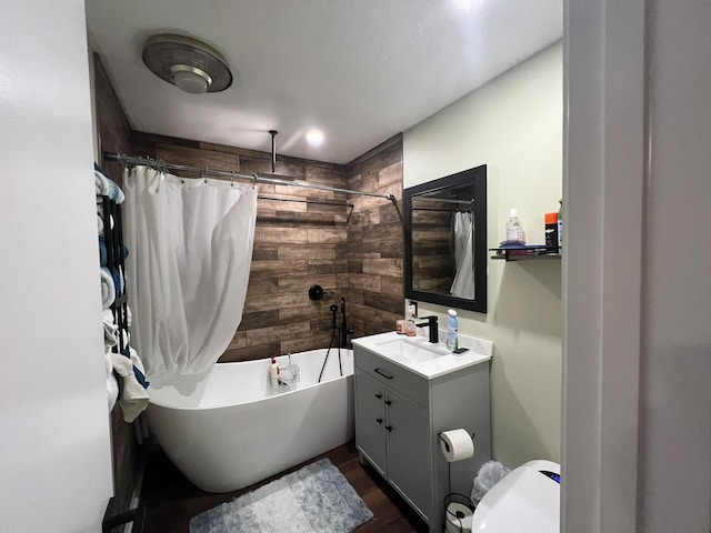 full bathroom featuring vanity, toilet, wood walls, and shower / bath combo with shower curtain