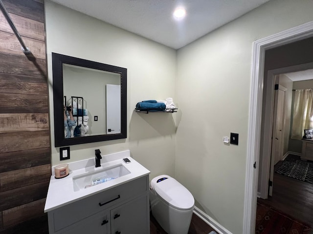 bathroom with vanity, toilet, and hardwood / wood-style floors