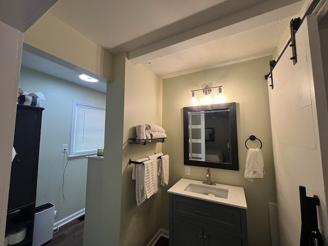 bathroom featuring a textured ceiling, vanity, and wood-type flooring