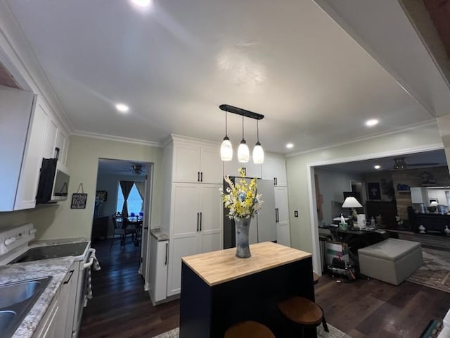 kitchen featuring white cabinetry, butcher block counters, a center island, dark hardwood / wood-style floors, and appliances with stainless steel finishes