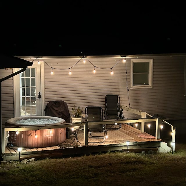 rear view of property featuring a hot tub and a deck