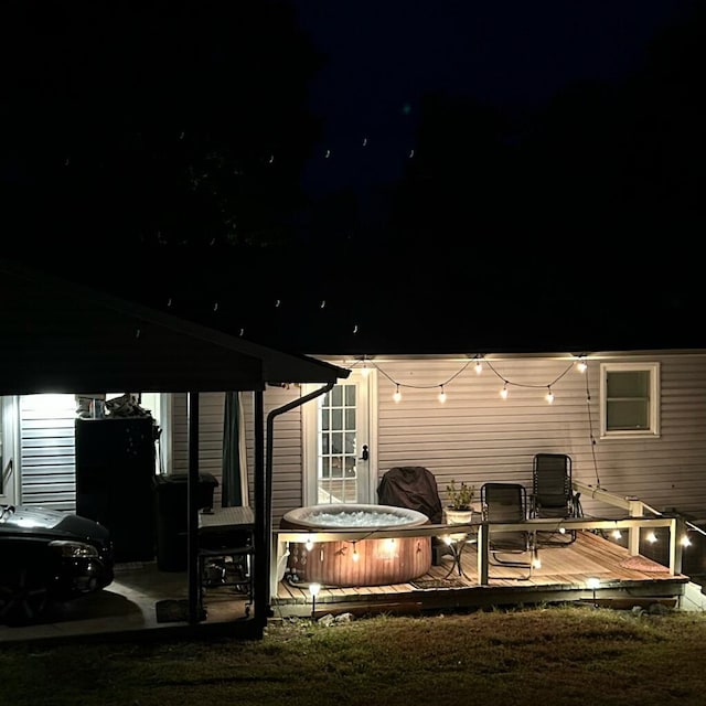 back house at twilight with a deck and a hot tub