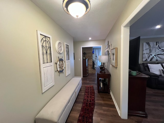 hallway with dark wood-type flooring and a textured ceiling