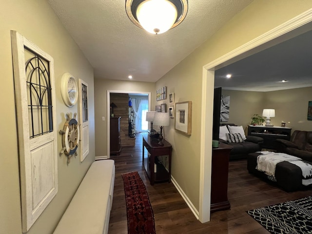 hall featuring a textured ceiling and dark hardwood / wood-style floors