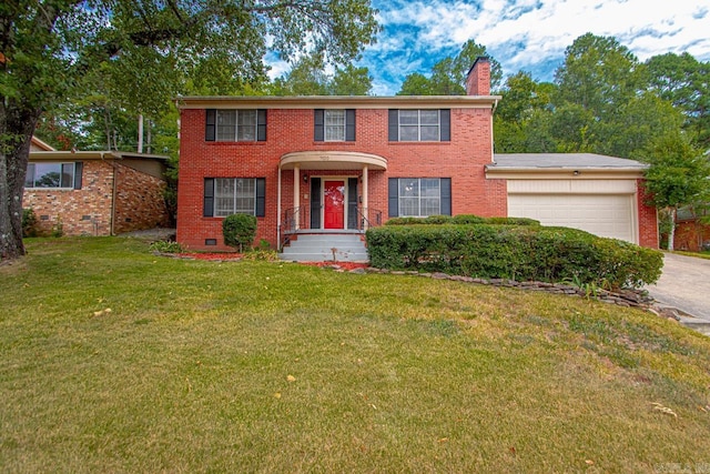 colonial home featuring a garage and a front lawn