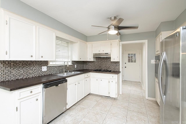 kitchen with white cabinets, stainless steel appliances, sink, ceiling fan, and decorative backsplash