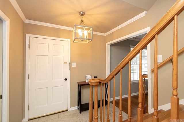 entryway featuring ornamental molding, light wood-type flooring, and a chandelier