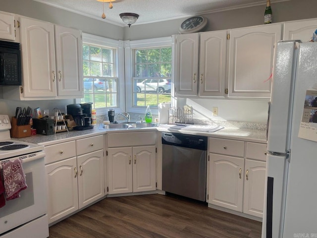 kitchen with white appliances, dark hardwood / wood-style flooring, sink, and white cabinets