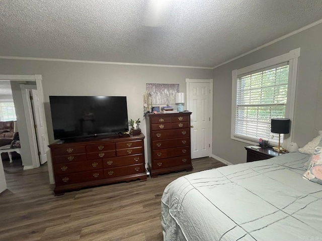 bedroom featuring crown molding, dark wood-type flooring, and a textured ceiling