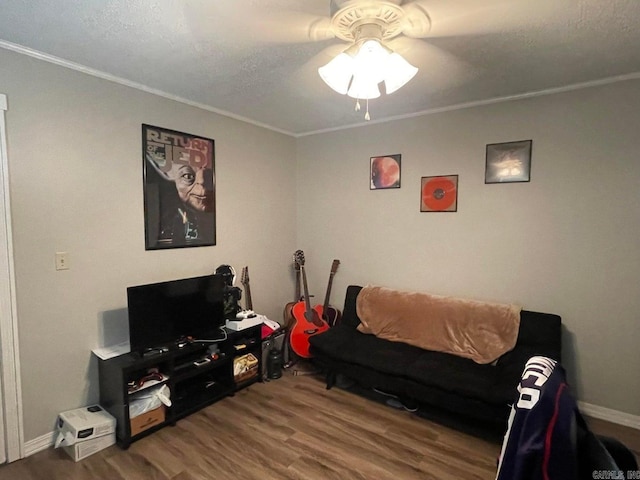 living room featuring ceiling fan, hardwood / wood-style flooring, a textured ceiling, and ornamental molding