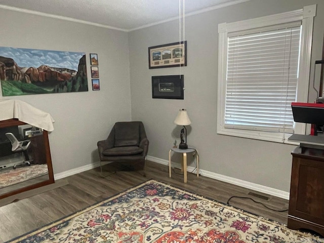 living area with crown molding and wood-type flooring