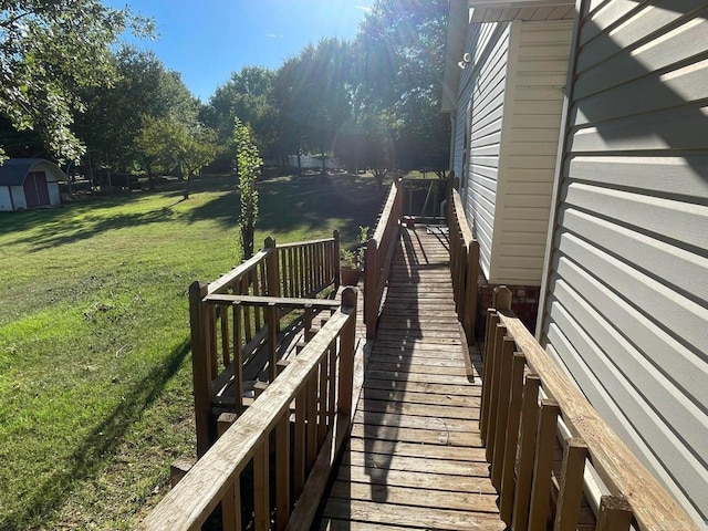 wooden deck with a lawn and a storage unit