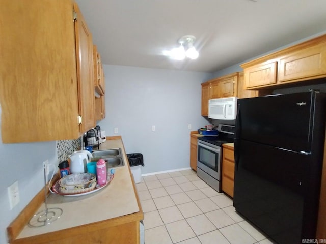 kitchen featuring black refrigerator, light tile patterned floors, and electric stove