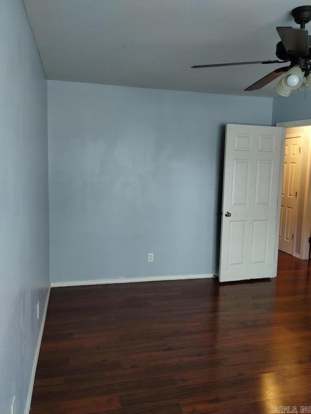 empty room featuring ceiling fan and dark hardwood / wood-style floors