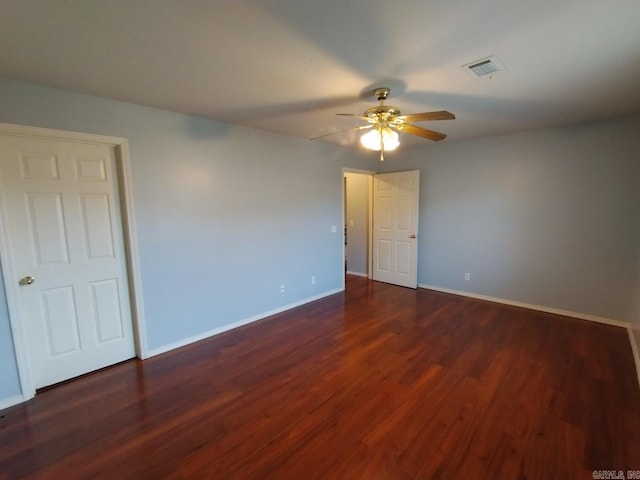 empty room featuring dark wood-type flooring and ceiling fan