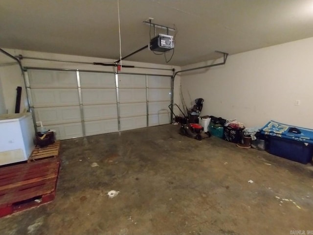 garage featuring white fridge and a garage door opener