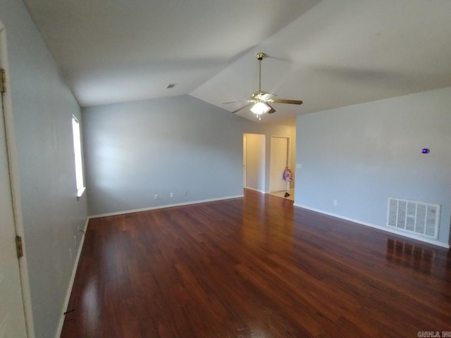 empty room with ceiling fan, dark hardwood / wood-style flooring, and vaulted ceiling