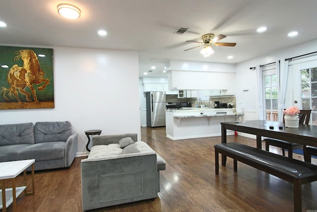 living room with ceiling fan and dark hardwood / wood-style flooring