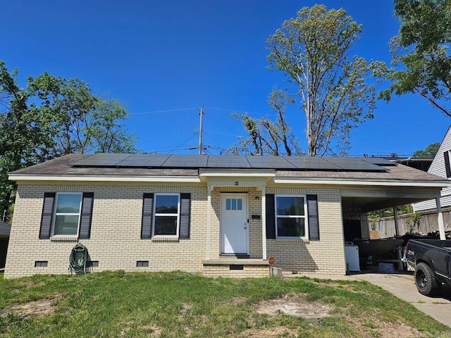 view of front of house featuring a front lawn, a carport, and solar panels