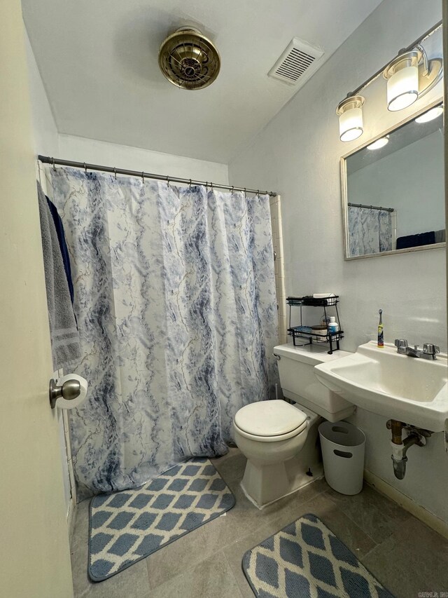 bathroom with toilet, a shower with curtain, and tile patterned flooring