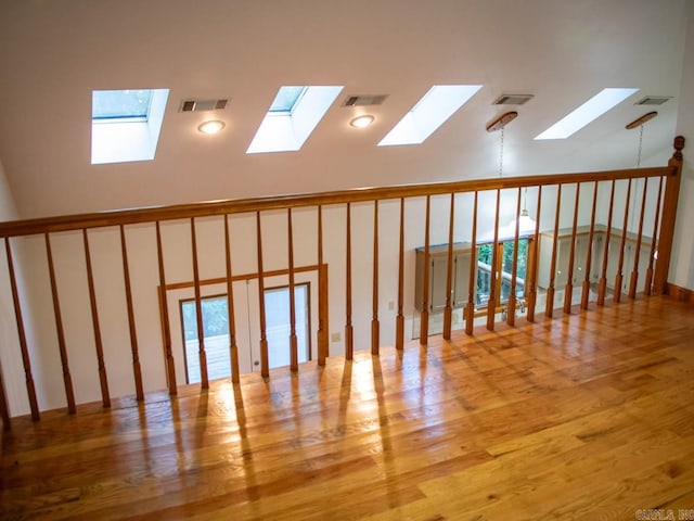 unfurnished room featuring light wood-type flooring, a skylight, and a healthy amount of sunlight