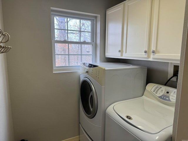 washroom featuring plenty of natural light, cabinets, and washer and dryer