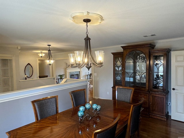 dining room with dark wood-type flooring, a notable chandelier, and ornamental molding