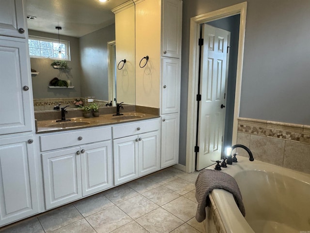 bathroom featuring tile patterned flooring, a washtub, and vanity